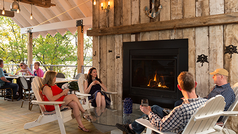 people sitting by outdoor fireplace