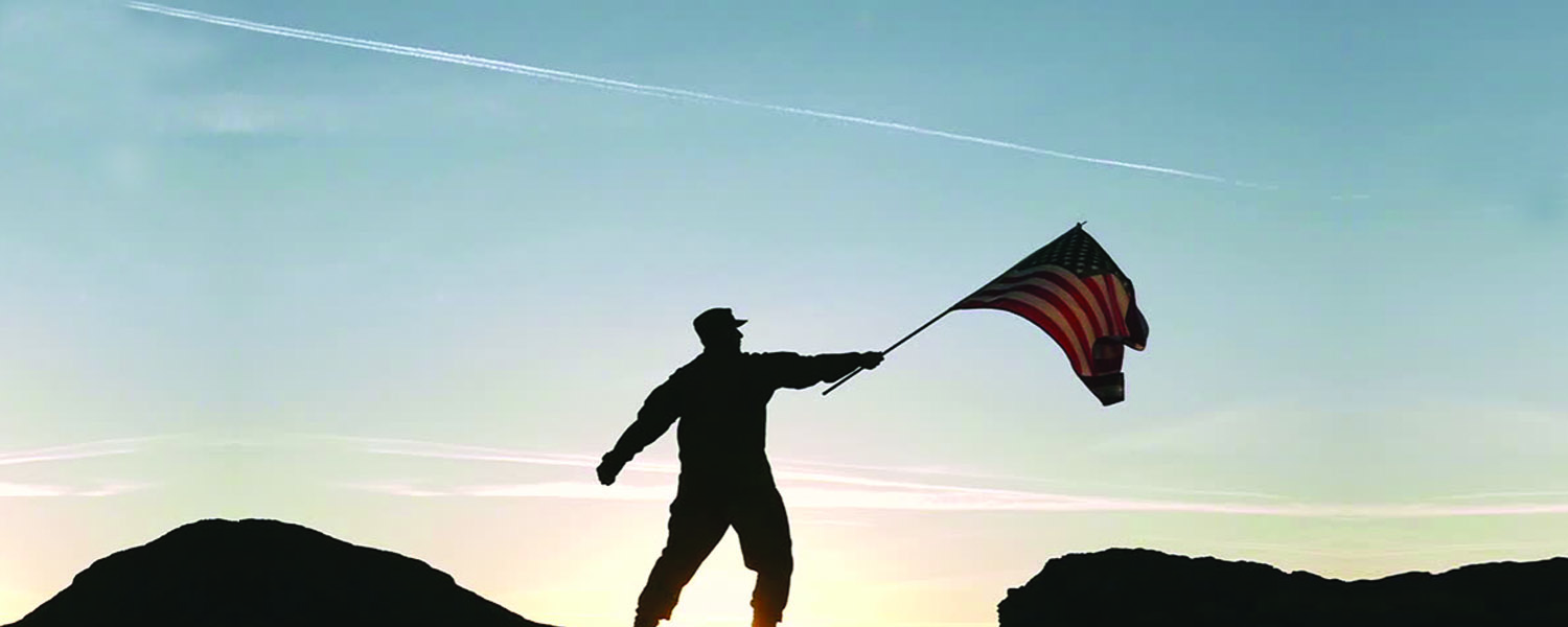 military servicemember holds up flag